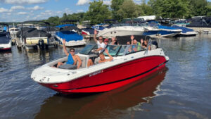 Bridge Marina Boating Club members smile and wave on Lake Hopatcong.