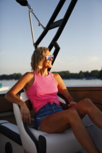 Woman enjoys the sunshine on Lake Hopatcong aboard a Starcraft pontoon boat from Bridge Marina. 