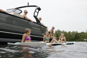 Family on Lake Hopatcong enjoys a Starcraft pontoon from Bridge Marina in the water.
